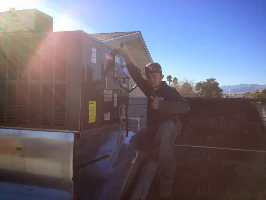 HVAC technician performing Air Duct Cleaning on a rooftop unit in Saranap